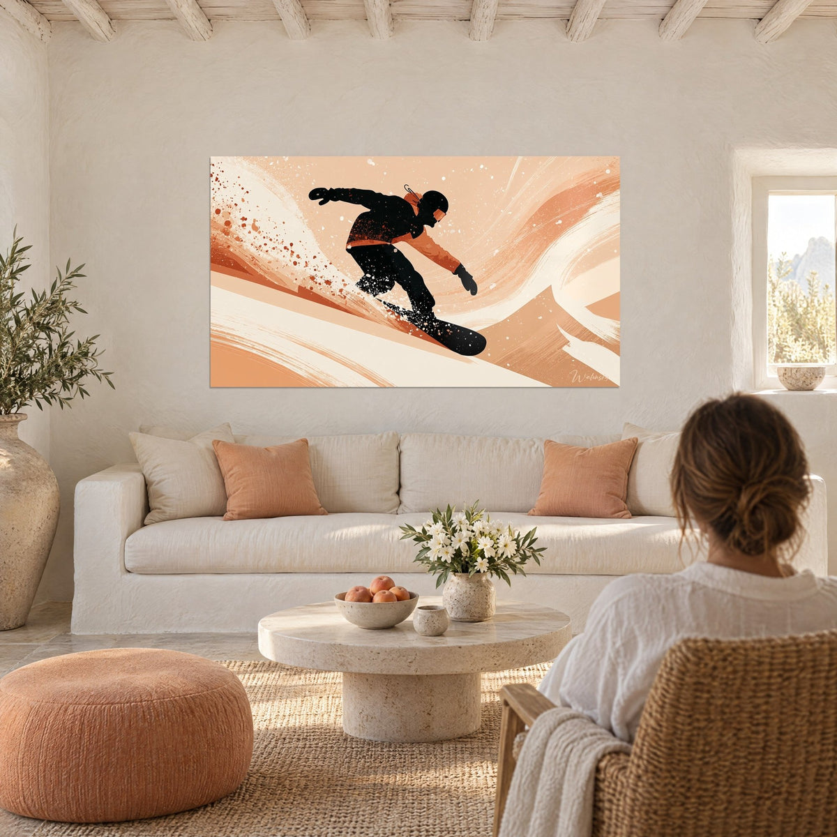 Tableau snowboardeur en combinaison noire dévalant une pente pêche et crème, au-dessus d'un canapé dans un salon lumineux