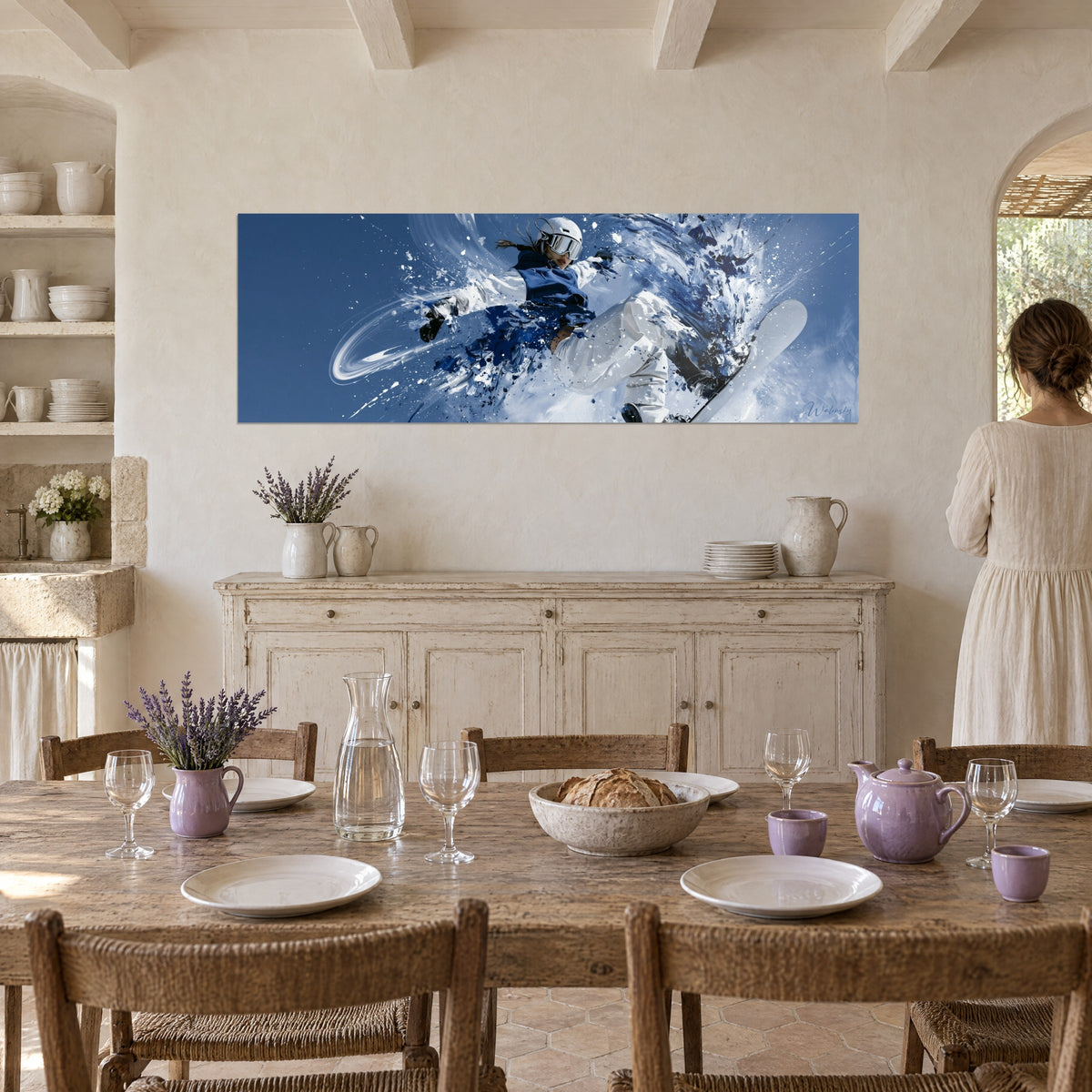 Schilderij poedersneeuwrijdster midden in de sprong, witte en koningsblauwe kleding, beige stucmuur van een Provençaalse eetkamer