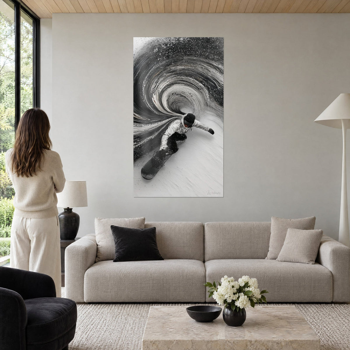 Tableau snowboardeur en veste blanche surfant un vortex d'encre noire et grise, femme de dos, au-dessus d'un canapé dans un salon lumineux