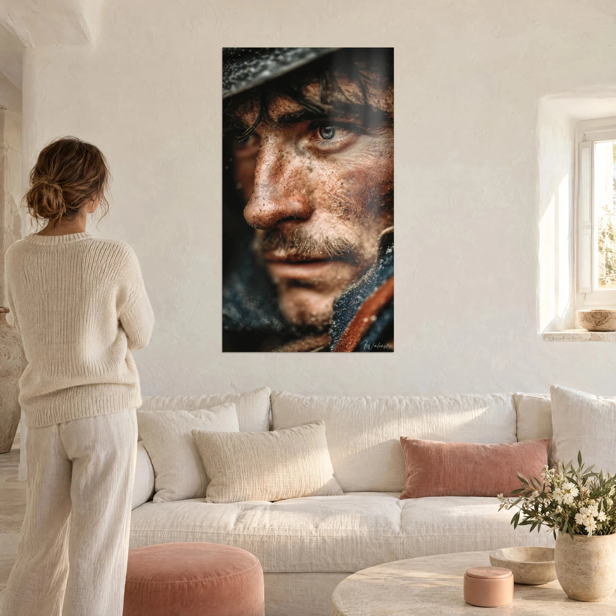 Wall art soldier with blue-grey gaze, face smeared with brown mud, black helmet, above a sofa in a bright living room
