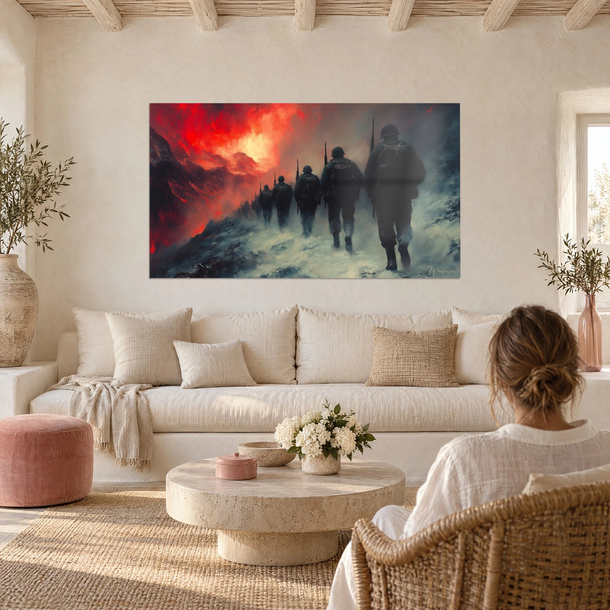 Wall art soldiers in helmets marching through snow under a blood-red sky, two people seen from behind above a sofa in a bright living room