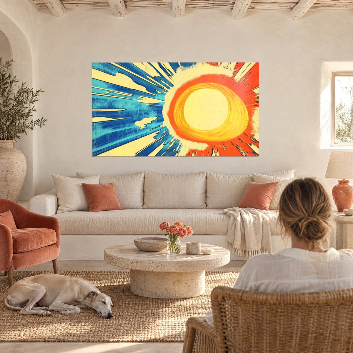 Tableau soleil radiant aux rayons bleu turquoise et orange vif, disque jaune pâle, au-dessus d'un canapé dans un salon lumineux