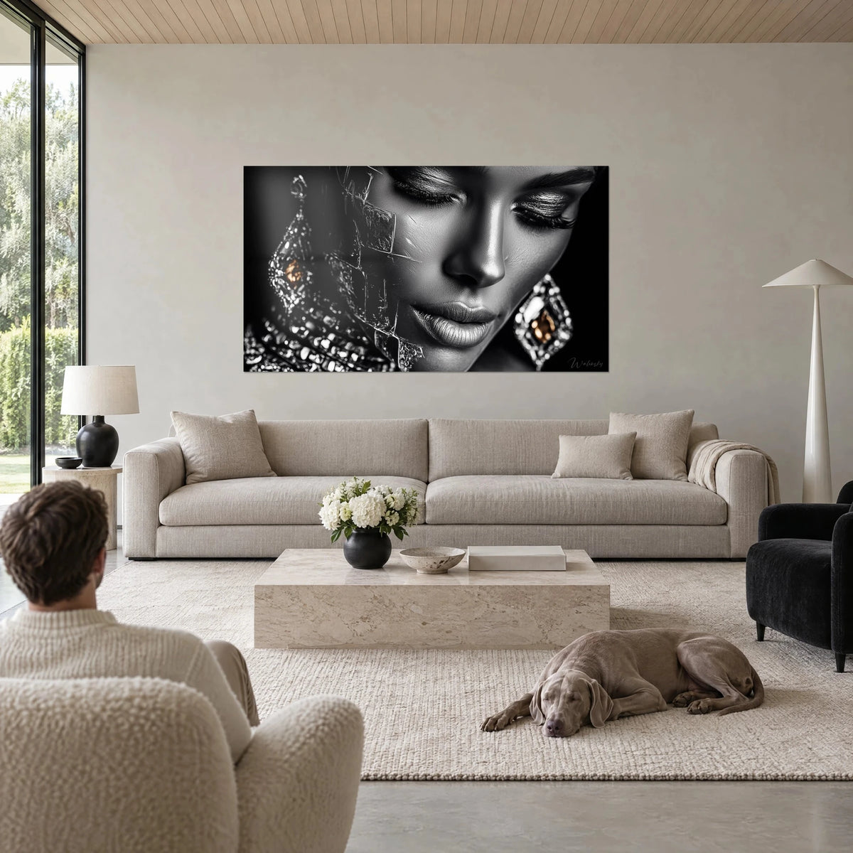 Cuadro retrato femenino en blanco y negro, párpados cerrados, pendientes de plata y cobre, encima de un sofá en un salón luminoso