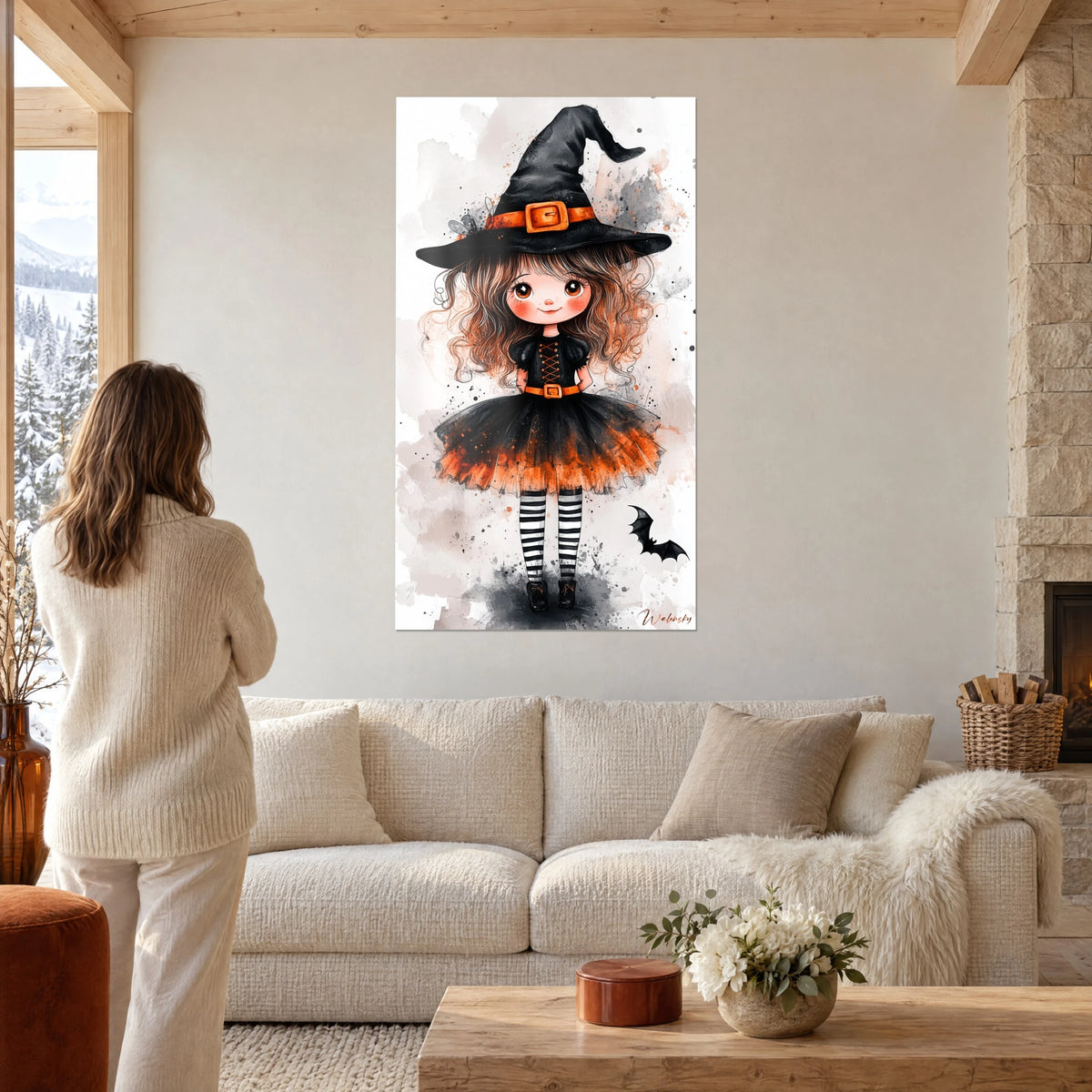 Gemälde kleine Hexe mit schwarzem Hut und orangefarbener Schleife, Rock aus schwarzem und orangefarbenem Tüll, über einem Sofa in einem hellen Wohnzimmer