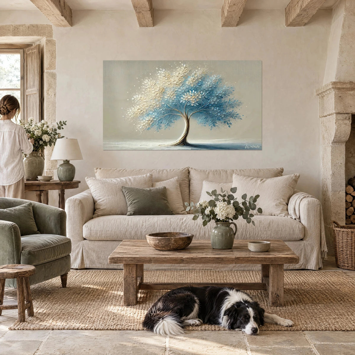 Wall art tree with ivory and sky-blue leaves, painted with a palette knife, above a sofa in a bright living room