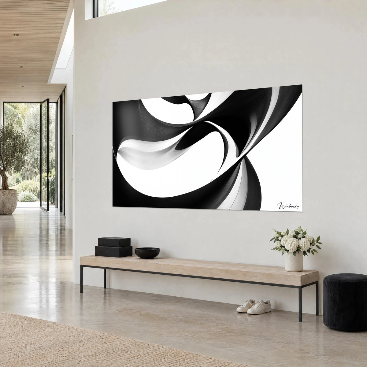 Quadro con un nastro scultoreo nero d'inchiostro avvolto su se stesso, pieghe grigio perla, parete color crema, console in legno, vista di tre quarti