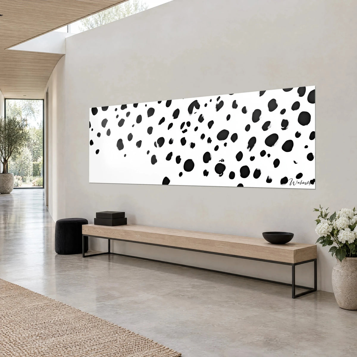 Wall art with abstract dalmatian coat pattern, black ink on pure white, beige wall and light wooden bench, three-quarter view