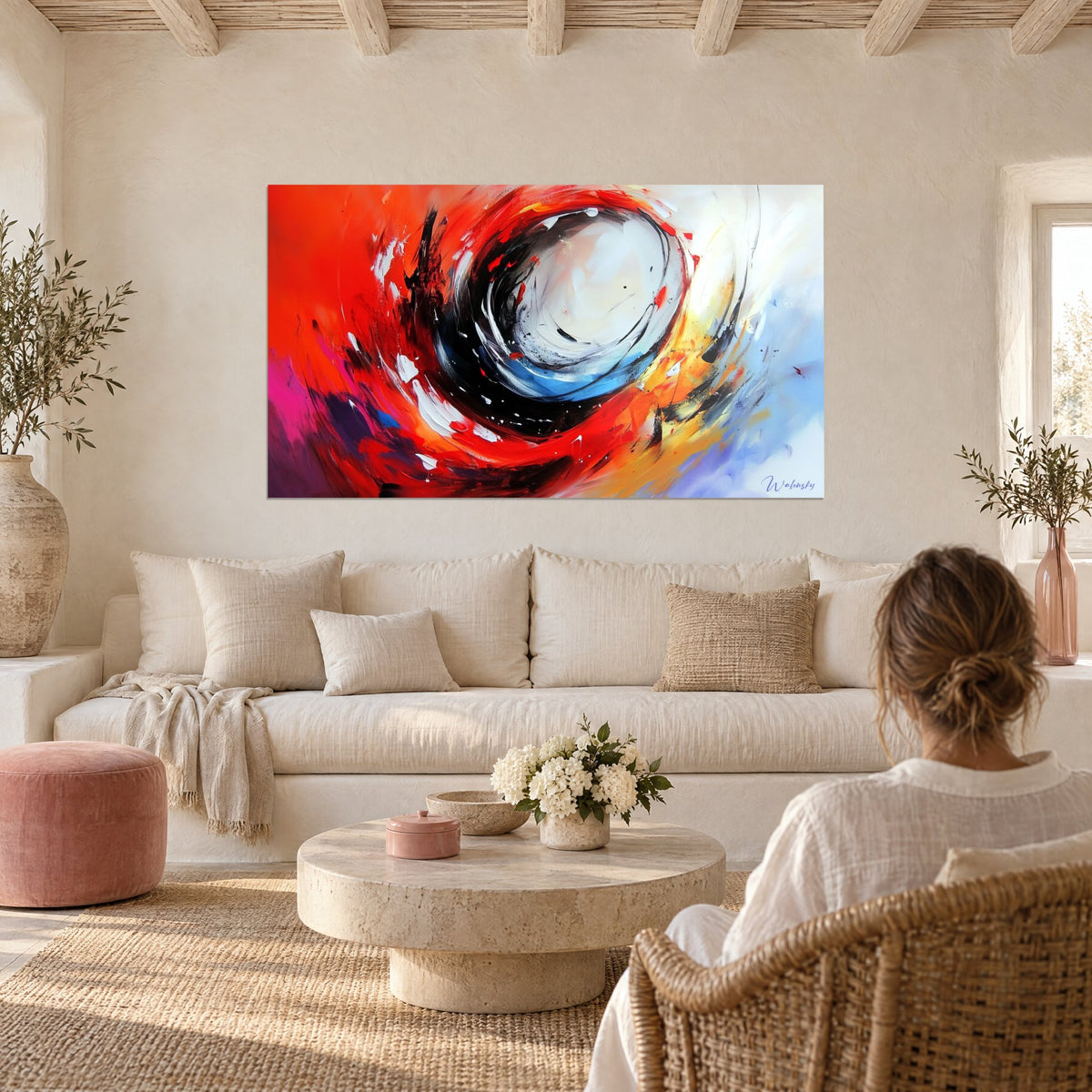 Schilderij spiraal in vermiljoen rood en zwart die een wit hart omcirkelt, blauwe accenten, boven een bank in een lichte woonkamer