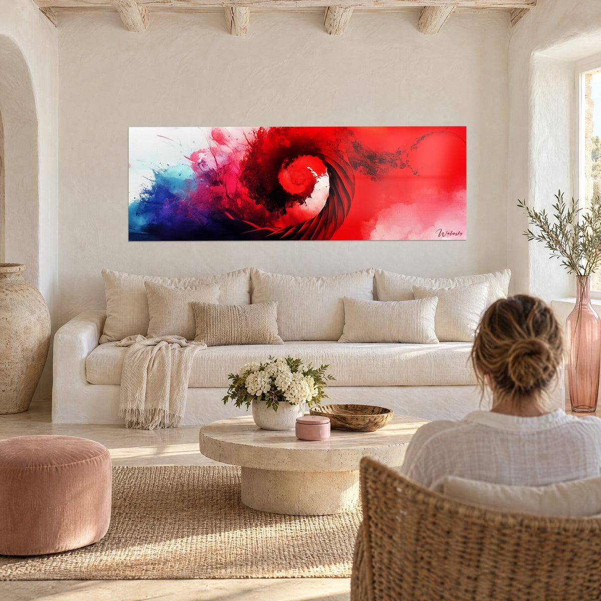 Gemälde mit roter Spirale, scharlachrot und blau-schwarz gesprenkelt, über einem Sofa in einem hellen Wohnzimmer