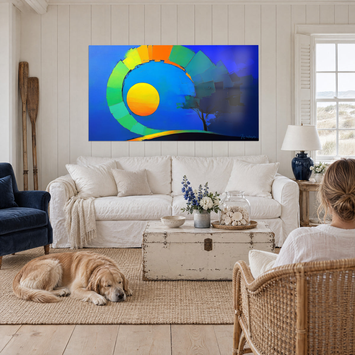Tableau soleil orangé dans une spirale verte et jaune sur fond bleu nuit, une femme et son retriever, au-dessus d'un canapé dans un salon lumineux
