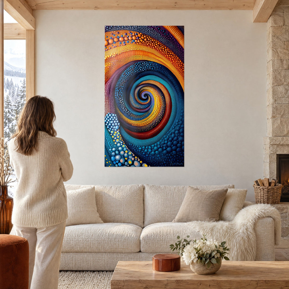 Tableau spirale de perles orange et bleu nuit, une femme de dos le regarde au-dessus d'un canapé dans un salon lumineux