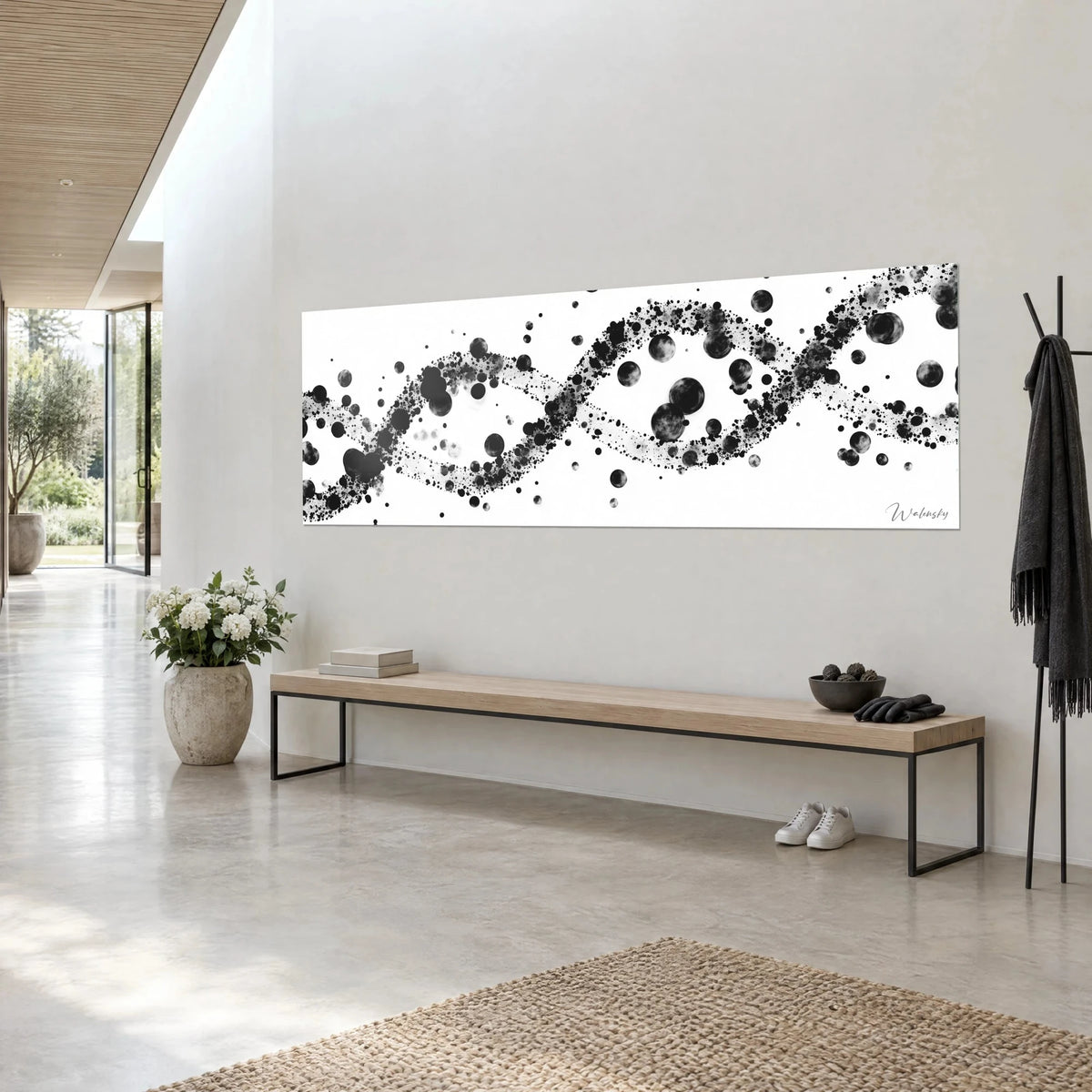 Wall art with a cosmic spiral of black and pearl-grey dot clouds, white panoramic format, three-quarter view on a light wall