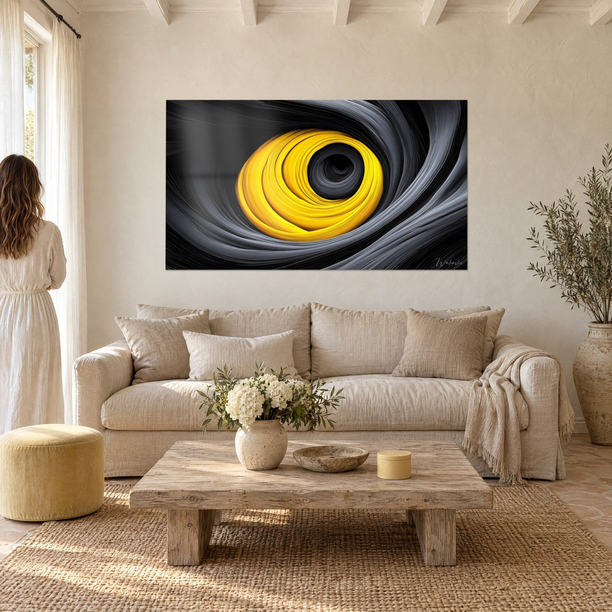 Tableau vortex jaune citron et noir charbon, couple de dos dans un mas provençal, au-dessus d'un canapé dans un salon lumineux