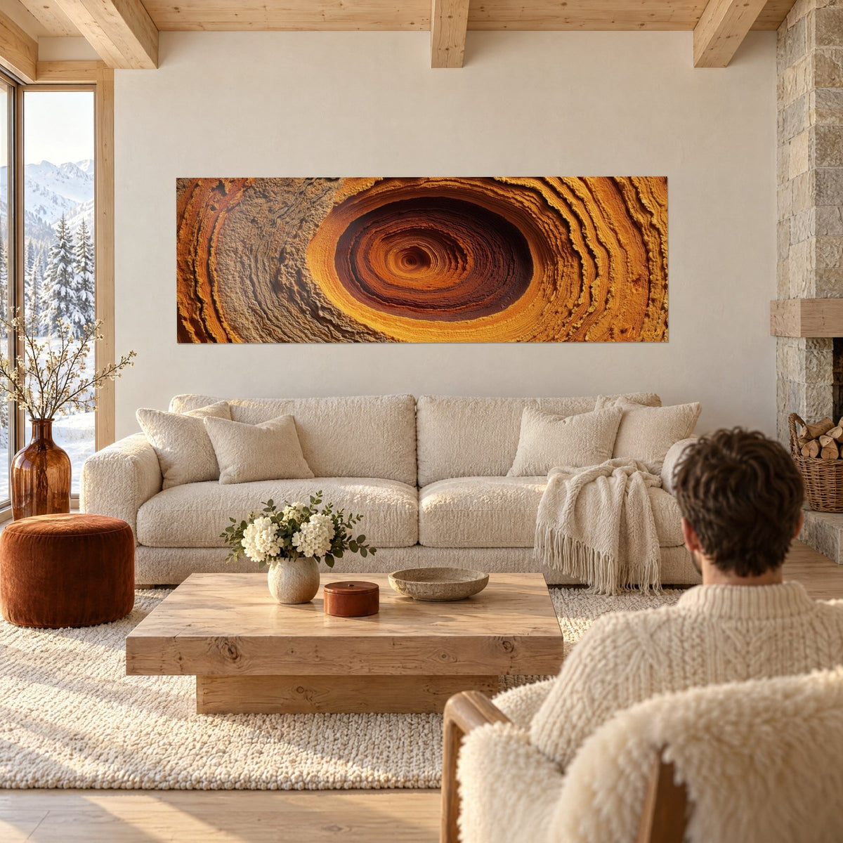Tableau spirale dorée aux anneaux ocre et cuivre, panoramique, accroché au-dessus d'un canapé dans un salon lumineux