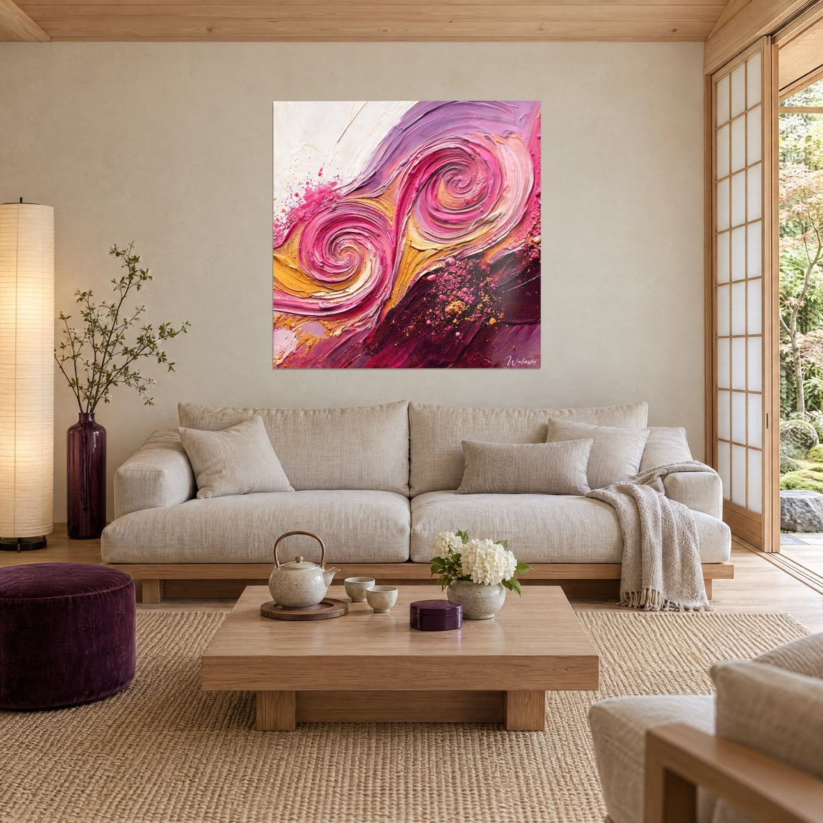 Tableau double volute rose fuchsia aux reliefs épais, fond crème et or, au-dessus d'un canapé dans un salon lumineux