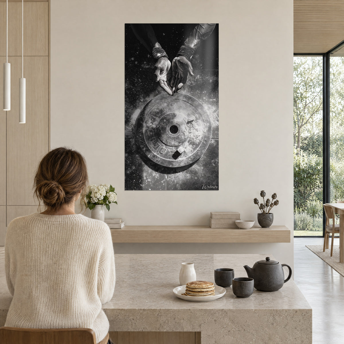 Schilderij pure kracht van een gietijzeren werper, open handpalmen bedekt met grijs en zwart krijt, aan de muur van een open keuken, een persoon zit met de rug toegekeerd aan tafel