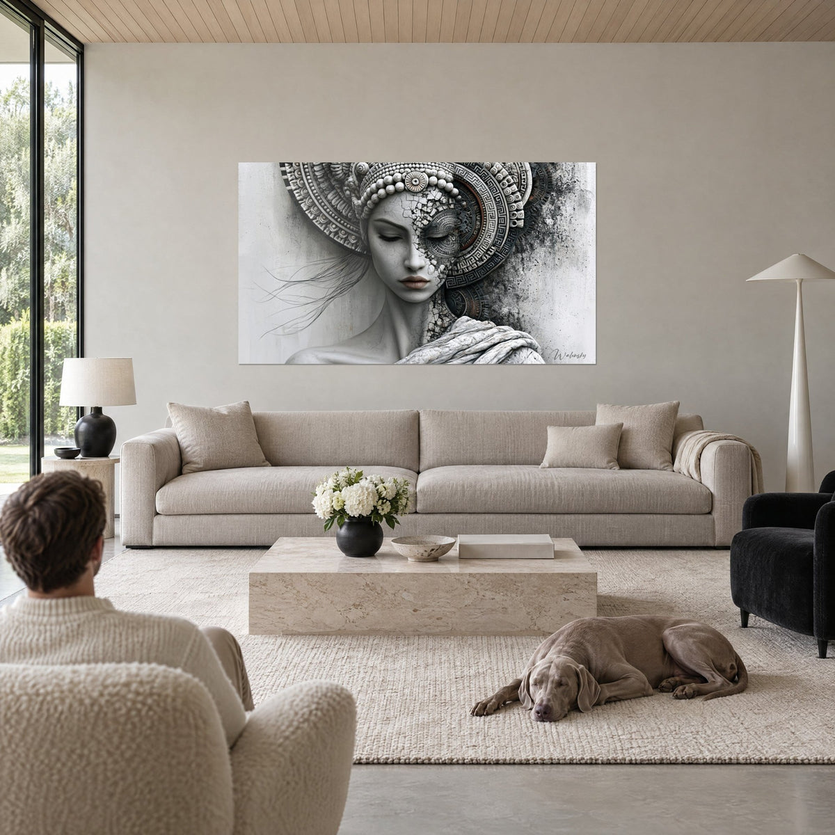 Cuadro rostro de estatua con párpados cerrados, tocado ornamentado en gris perla y antracita, sobre un sofá en un salón luminoso
