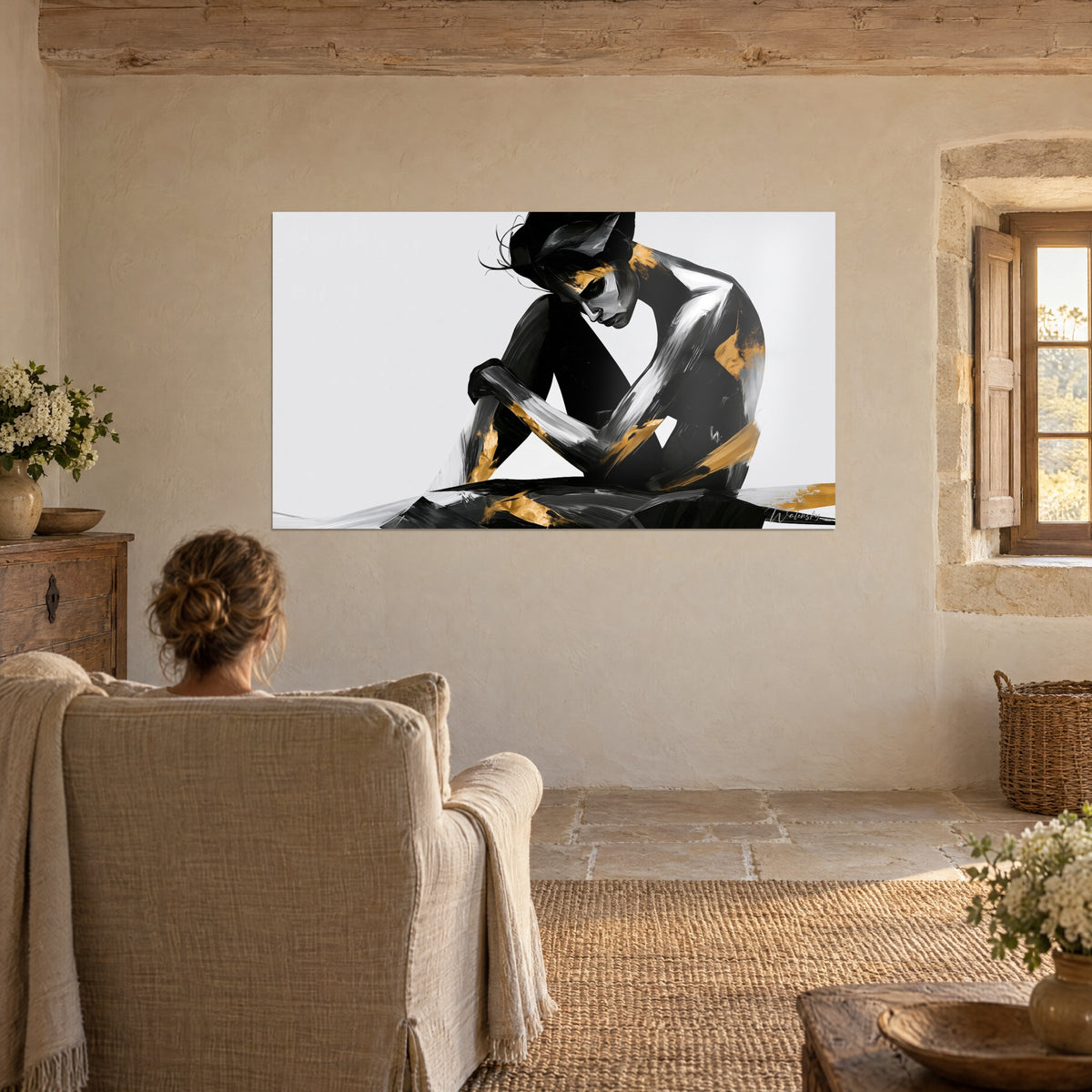 Wall art stylised nude in a folded position, black, silver and gold brush sweeps, facing a figure seen from behind in a beige armchair