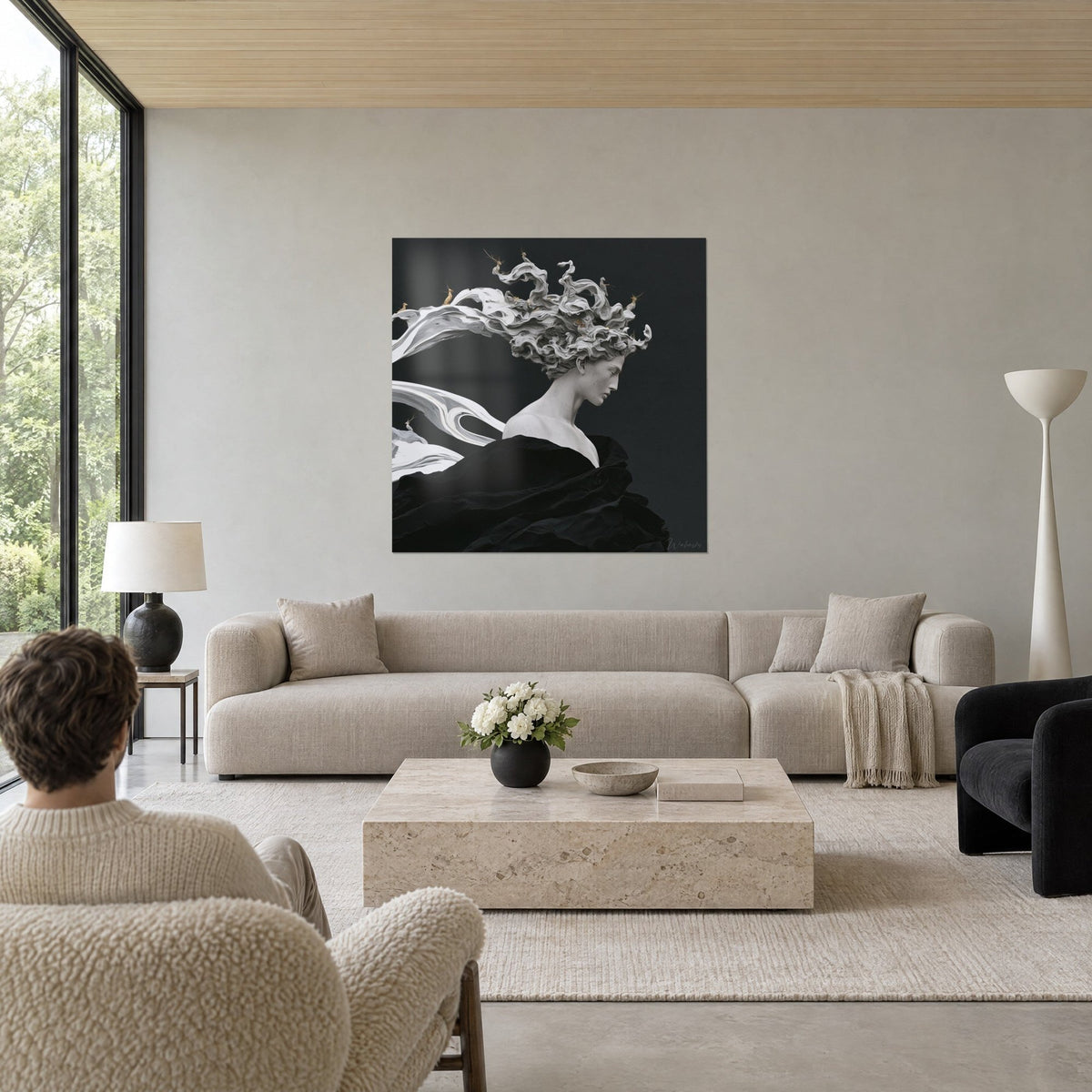 Tableau buste de marbre blanc aux boucles tourbillonnantes sur fond noir, drapé charbon, au-dessus d'un canapé dans un salon lumineux