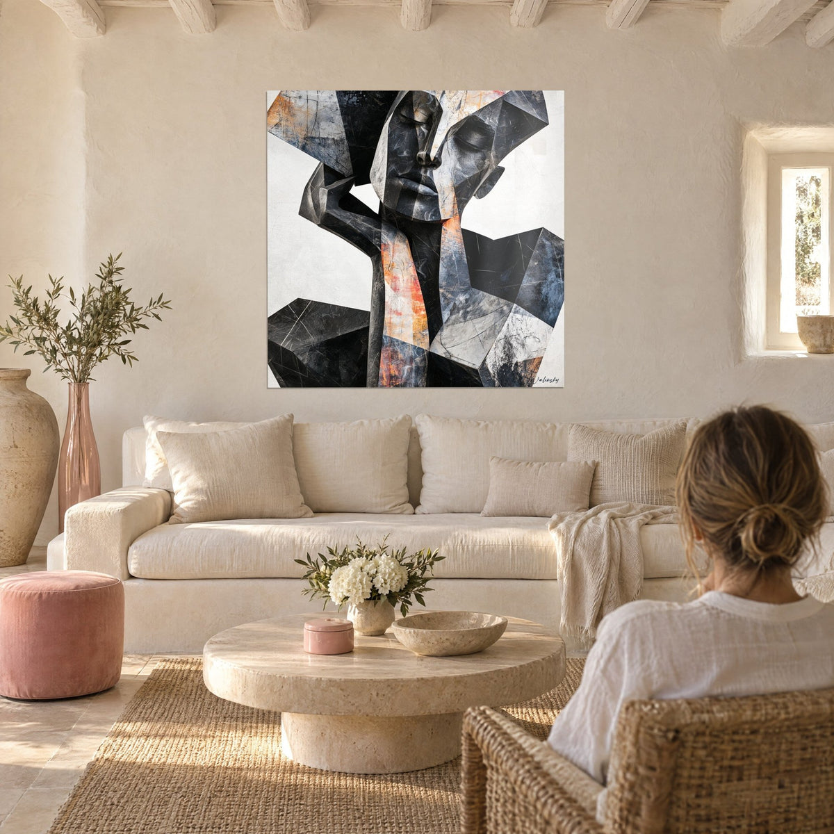 Quadro volto cubista antracite con schegge arancioni, palpebre chiuse, parete color crema, sopra un divano in un soggiorno luminoso
