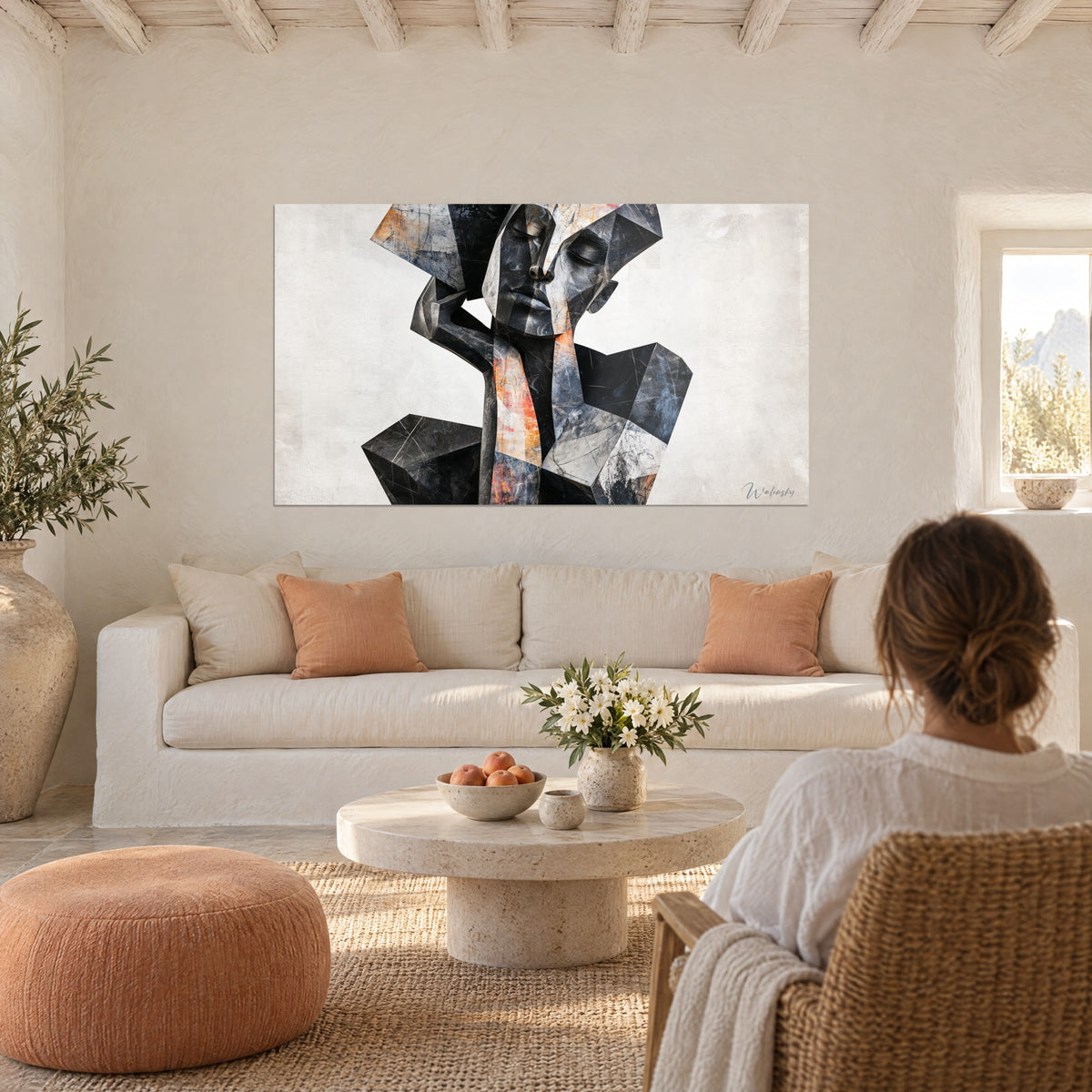 Schilderij cubistisch beeld met een antraciet gezicht en terracotta scherven, een vrouw van achteren kijkt ernaar boven een bank in een lichte woonkamer