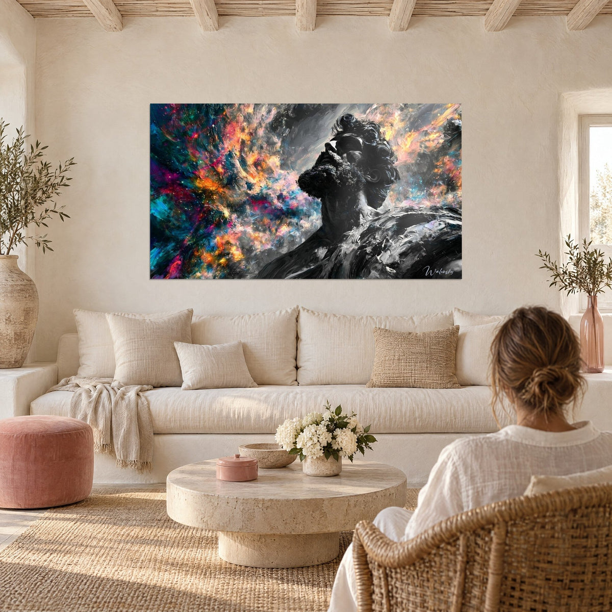 Quadro statua barbuta in bianco e nero, nebulosa rosa e arancione, coppia di spalle sopra un divano in un soggiorno luminoso