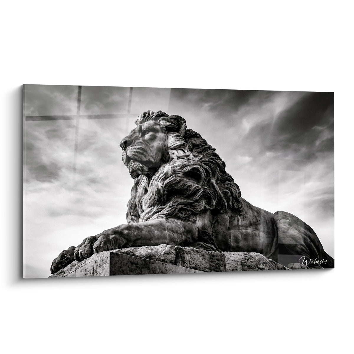 Statue de lion en pierre gris anthracite, crinière sculptée, ciel nuageux blanc en arrière-plan