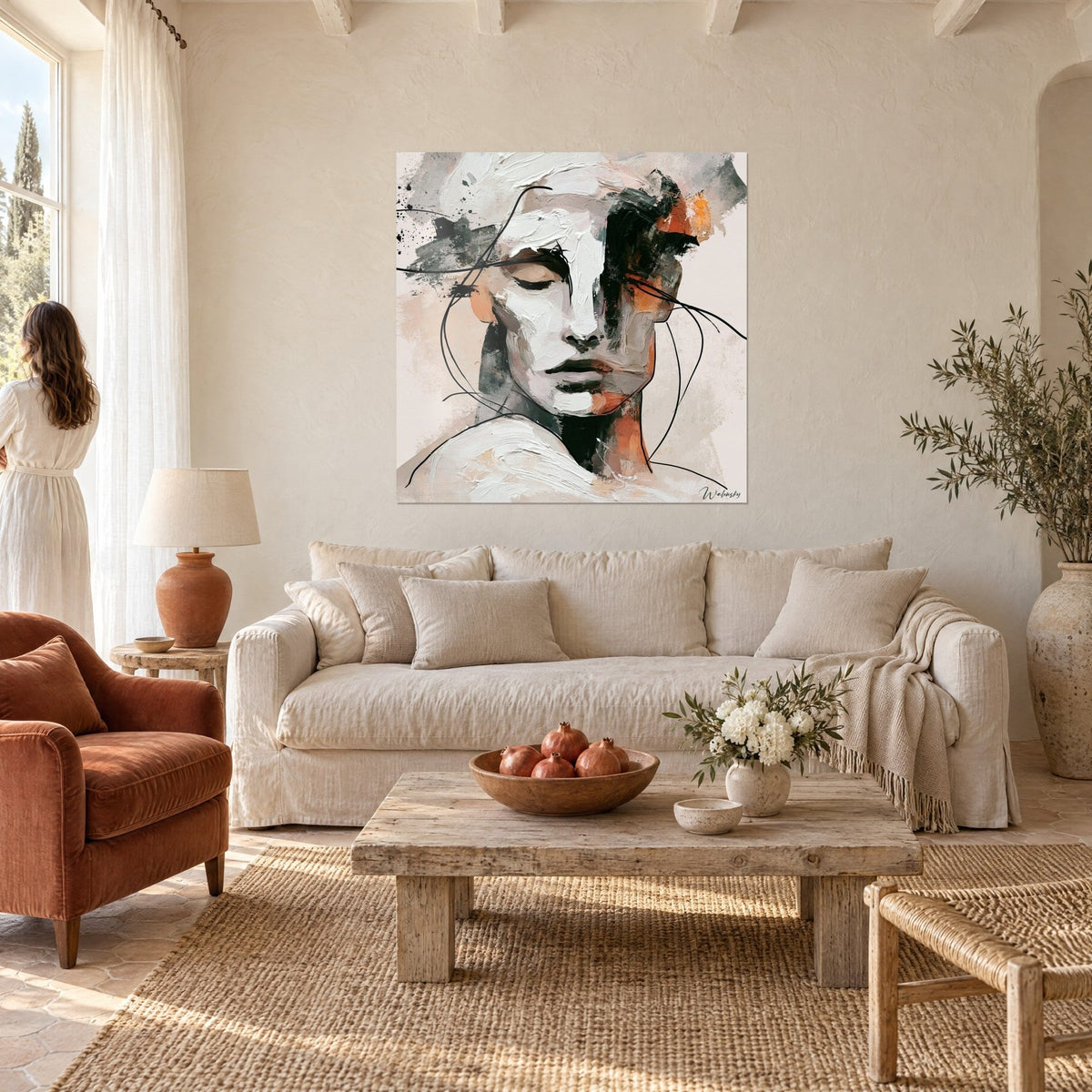Tableau visage blanc aux empâtements épais, joues terracotta et traits noirs filiformes, femme de dos au-dessus d'un canapé dans un salon lumineux