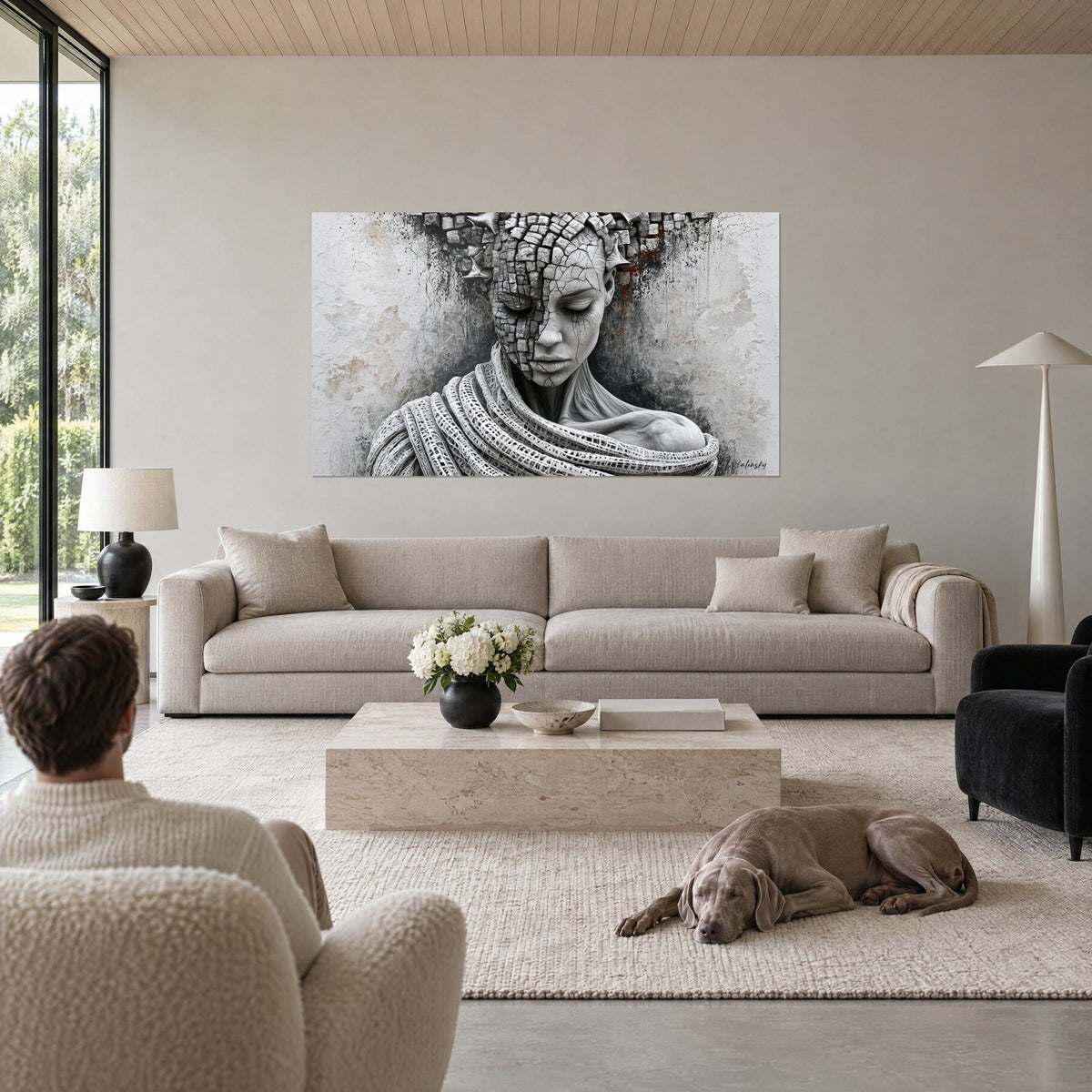 Tableau visage de statue fissuré en mosaïque grise, écharpe tressée blanche, éclats rouille, au-dessus d'un canapé dans un salon lumineux