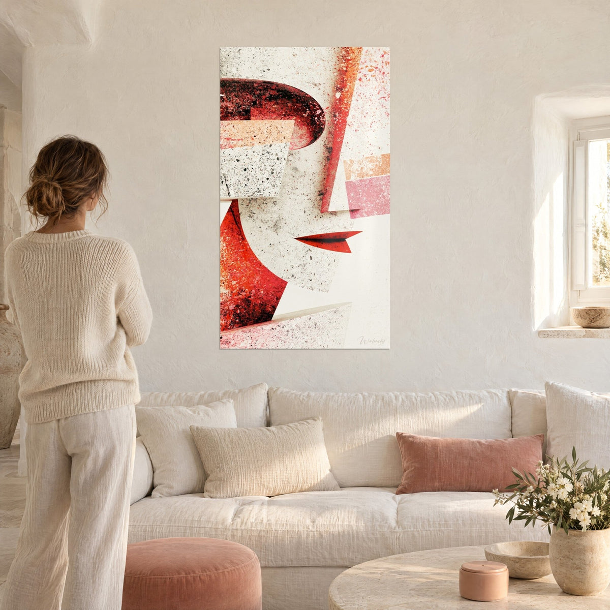 Gemälde Skulpturales Gesicht in roten und cremefarbenen Flächen, geschwungene purpurne Nase, schwarze Spritzer, über einem Sofa in einem hellen Wohnzimmer