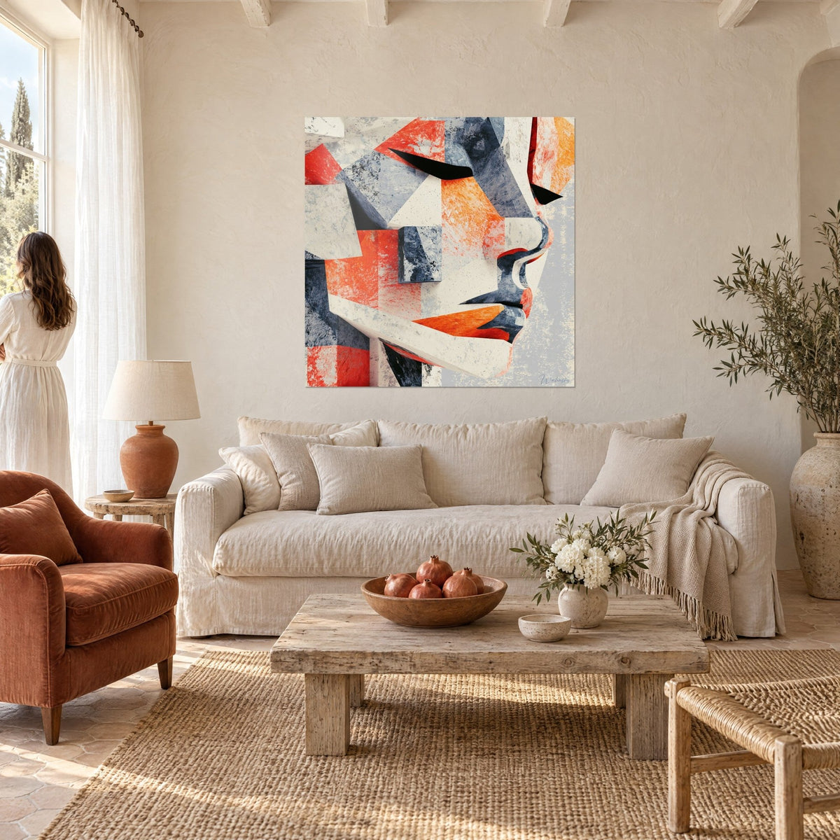 Tableau profil sculpté en facettes orange et anthracite, nez saillant, lèvres rouges, au-dessus d'un canapé dans un salon lumineux