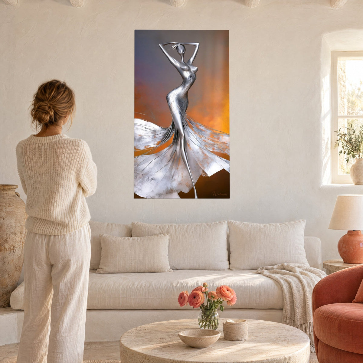 Wall art silver statue with raised arms, steel gown spread out against an amber and violet background, woman seen from behind above a sofa in a bright living room