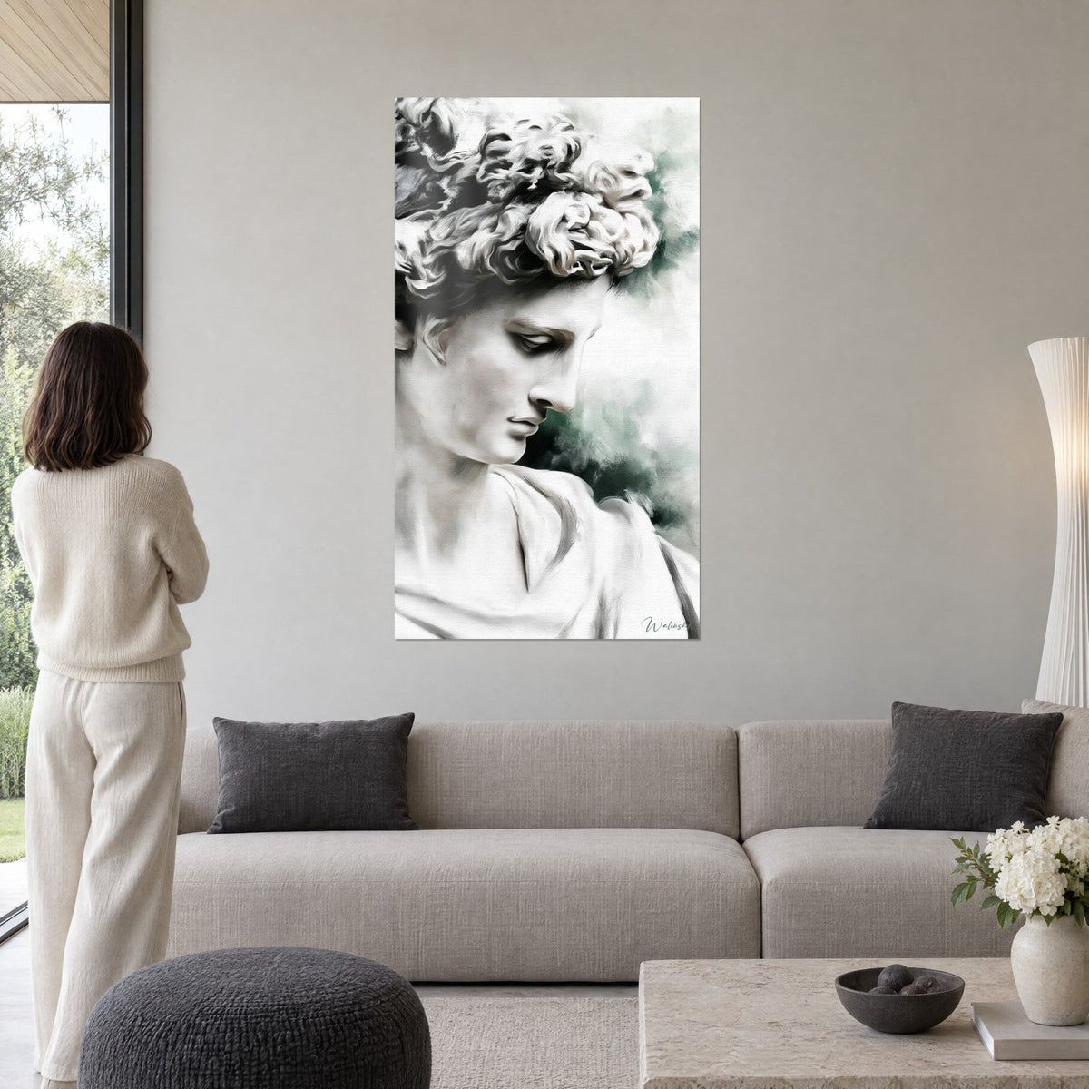 Tableau buste de marbre aux boucles blanches, visage penché sur fond brumeux vert, au-dessus d'un canapé dans un salon lumineux