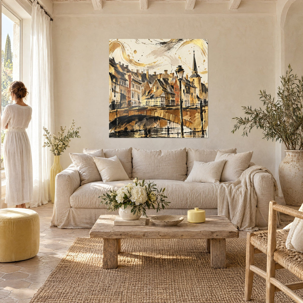 Gemälde Fachwerkhäuser in Ockerfarbe am Kanal, schwarze Laterne und goldene Schlieren, über einem Sofa in einem hellen Wohnzimmer