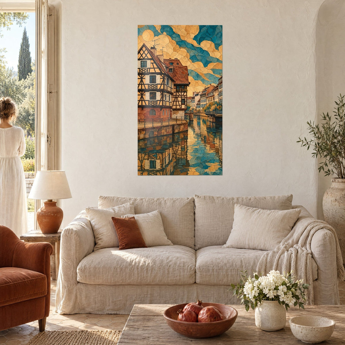 Cuadro de una casa con entramado de madera marrón y ocre, cielo turquesa agrietado, canal con reflejos, colgado sobre un sofá en un salón luminoso