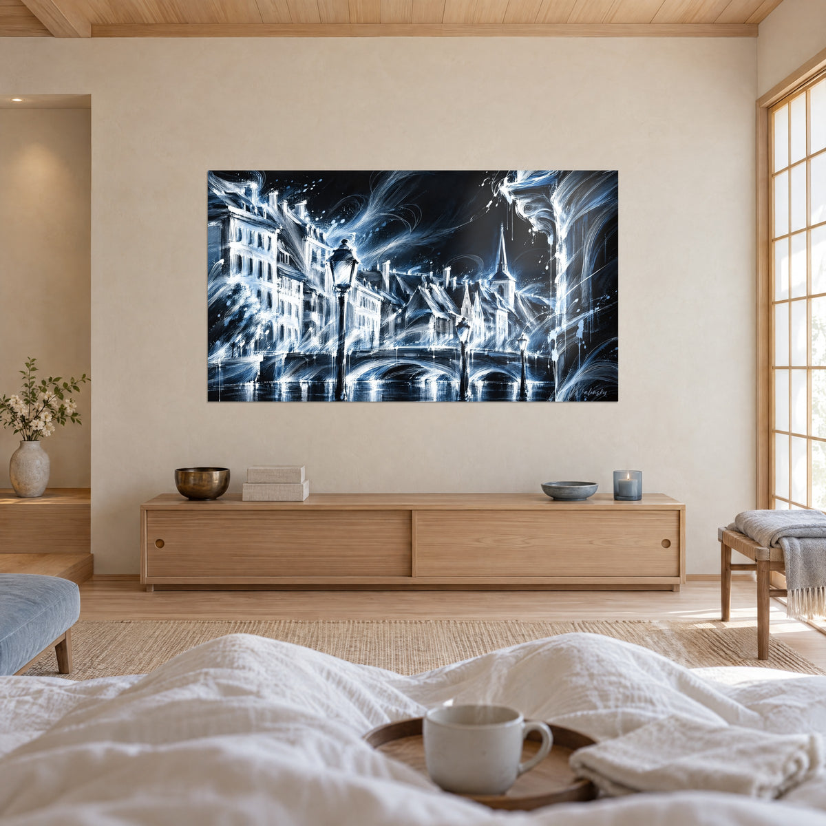 Schilderij van de Straatsburgse kade onder de maan in gletsjerblauw en wit, met bogen en gevels, van achteren gezien boven een bed in een lichte slaapkamer
