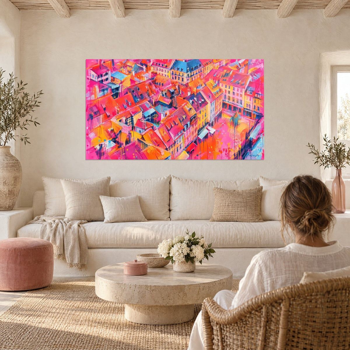 Quadro tetti rosa e arancioni visti dall'alto, facciate gialle, tetti in ardesia blu, sopra un divano in un soggiorno luminoso