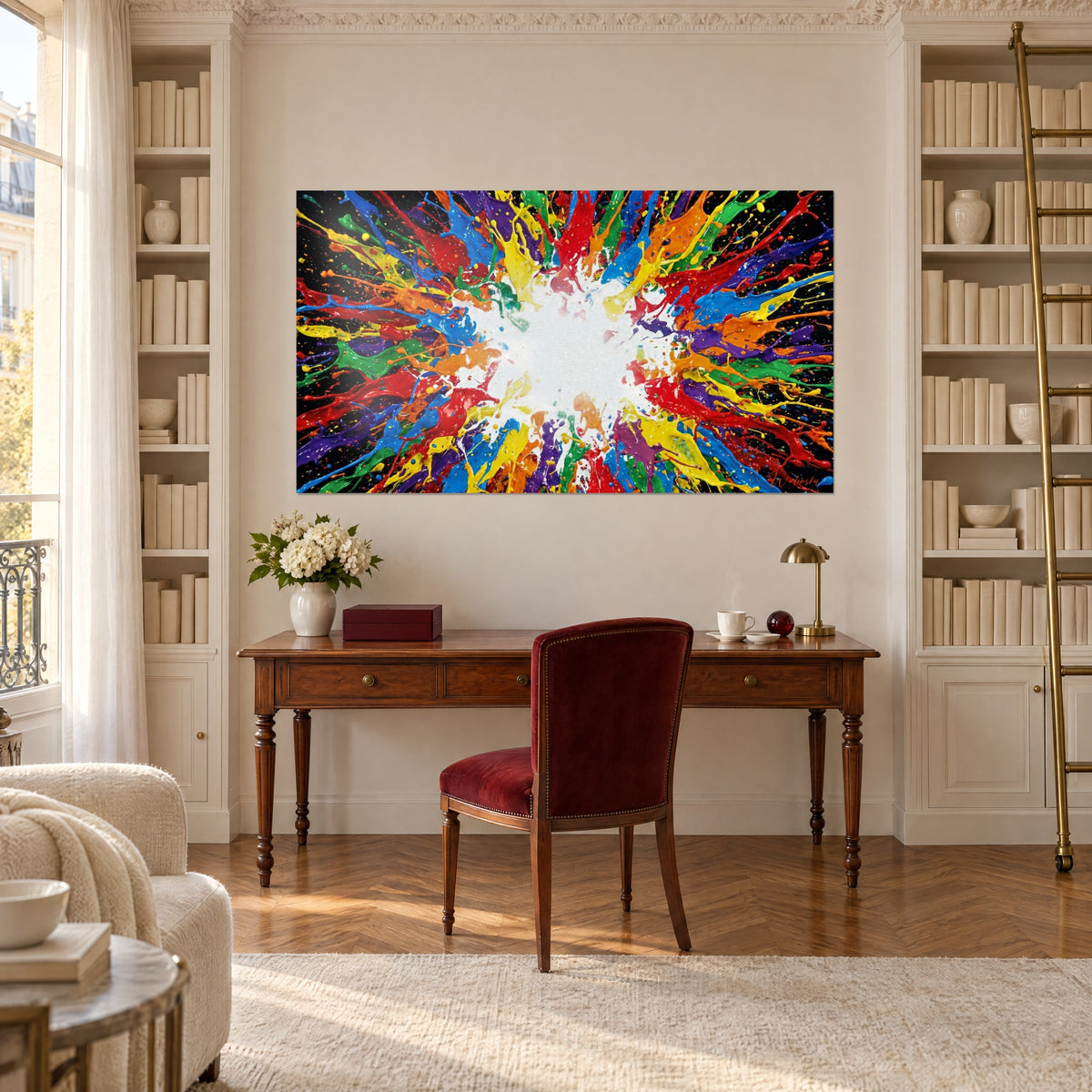 Quadro esplosione colorata di gocciolature blu e rosse attorno a un alone bianco, sopra una scrivania in legno tra due librerie