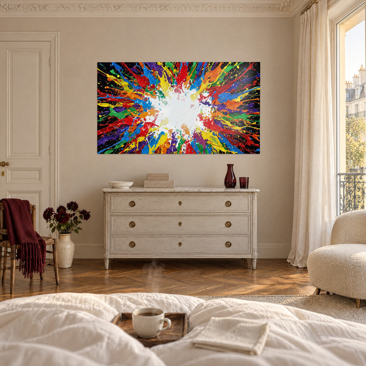 Quadro getti di pittura verdi, gialli e rossi che sprizzano da un centro bianco, sopra un letto in una camera luminosa