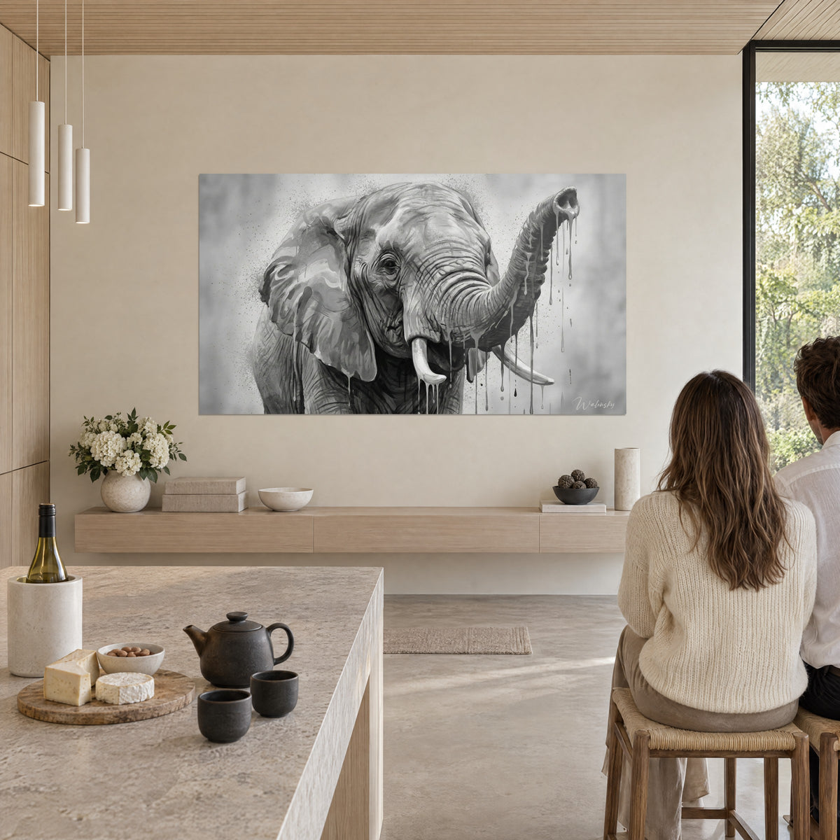 Tableau portrait d'éléphant au regard doux, gris charbon et blanc cassé, éclaboussures fines, dans un séjour lumineux en bois clair