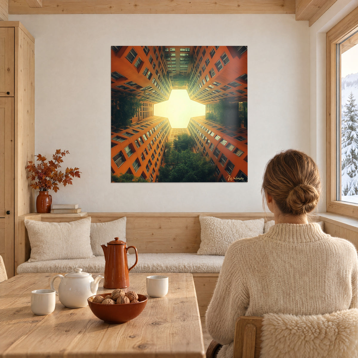 Gemälde orangefarbener Wolkenkratzer, die auf einen leuchtenden Himmel zulaufen, grüne Wipfel unten, gegenüber einem Holztisch eines Chalets