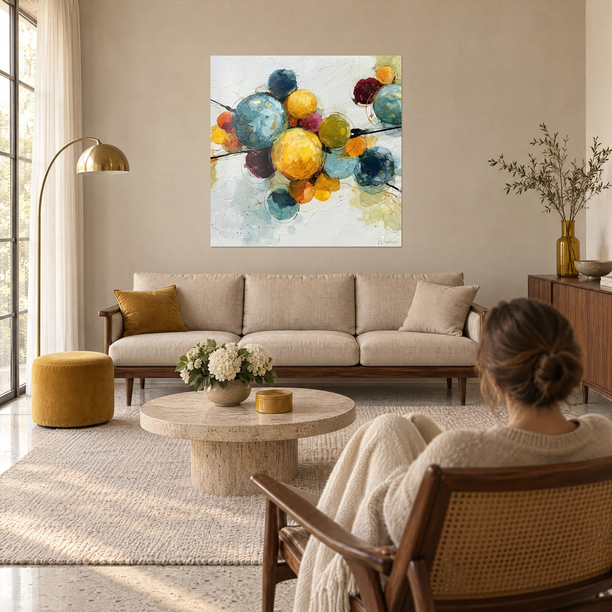 Schilderij met doorschijnende bollen in petroleumblauw en mosterdgeel, gouden accenten op crèmekleurige achtergrond, boven een bank in een lichte woonkamer