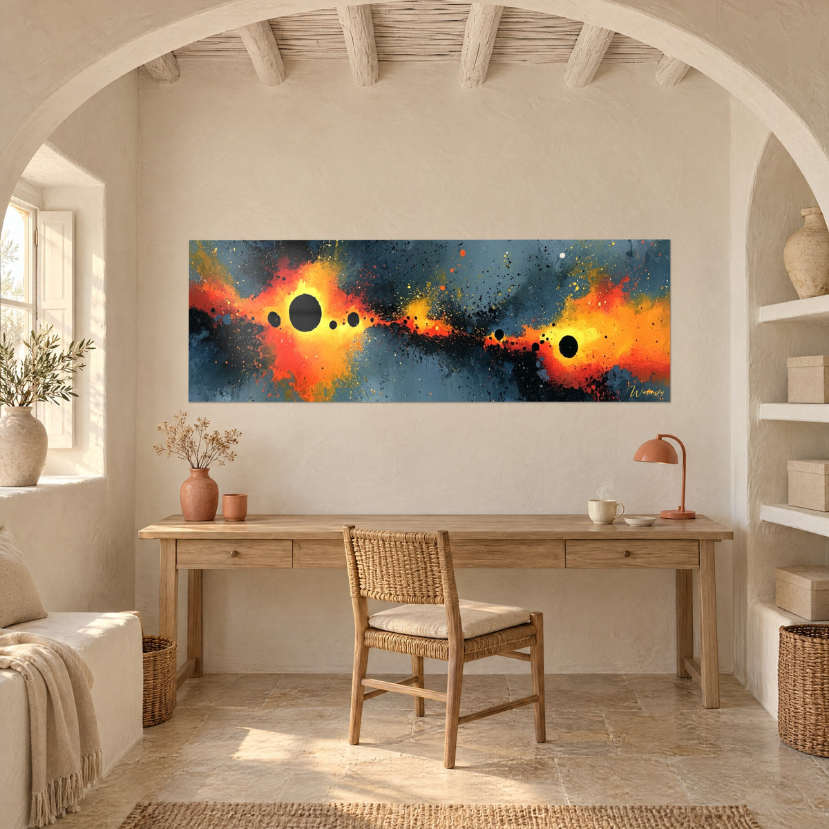 Schilderij kosmische explosie in oranje en geel bezaaid met zwarte bollen op een antracieten achtergrond, boven een bureau van licht hout naast een boog
