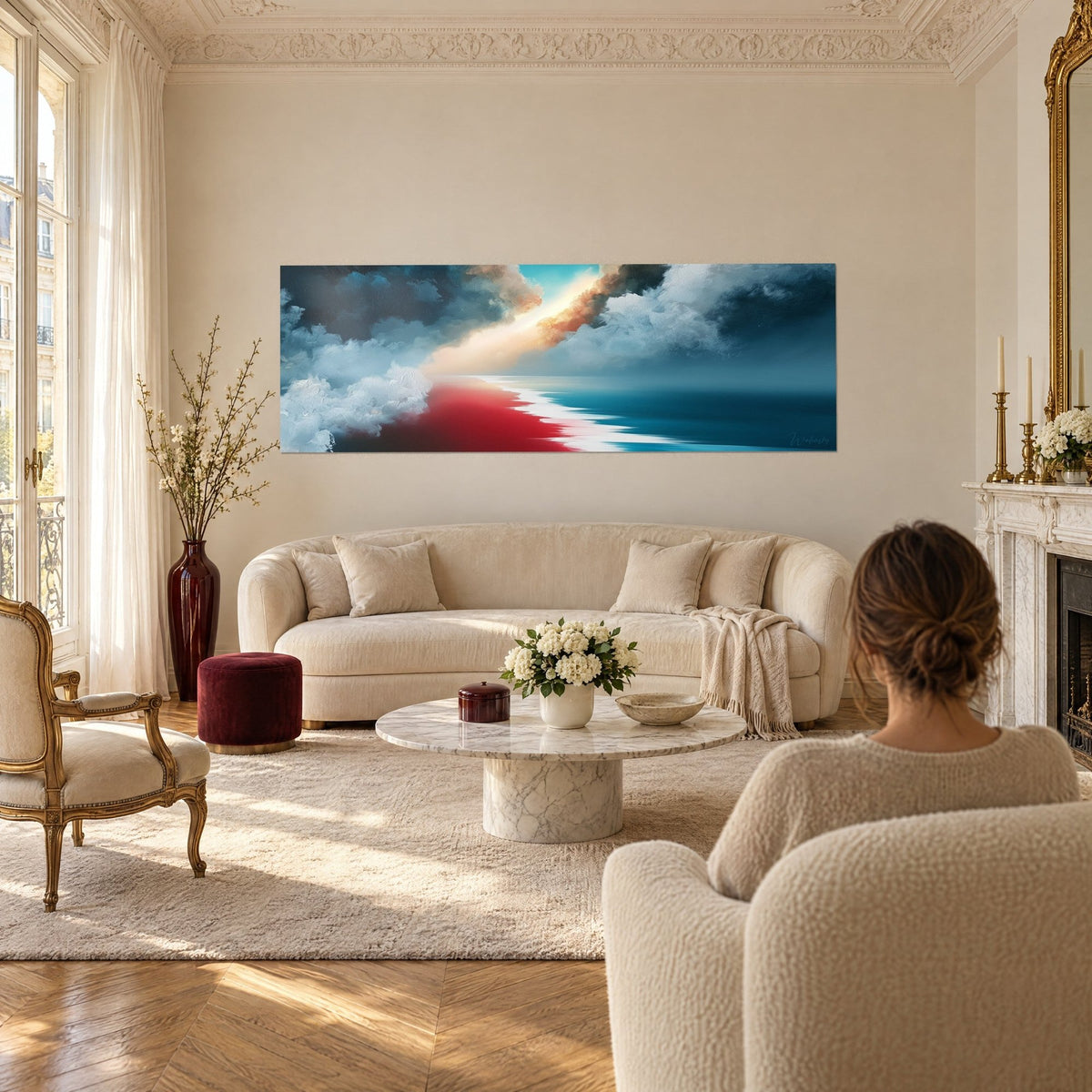 Tableau horizon marin partagé entre rivage rouge et mer bleu marine, trouée de lumière, au-dessus d'un canapé dans un salon lumineux
