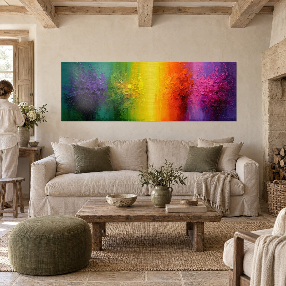Cuadro de bandas de color con empastes en morado, amarillo y rojo, visto de espaldas por una mujer, sobre un sofá en un salón luminoso