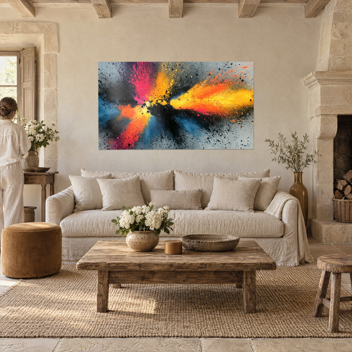 Tableau éruption de peinture orange et rose sur fond gris, éclats noirs, deux personnes de dos au-dessus d'un canapé dans un salon lumineux