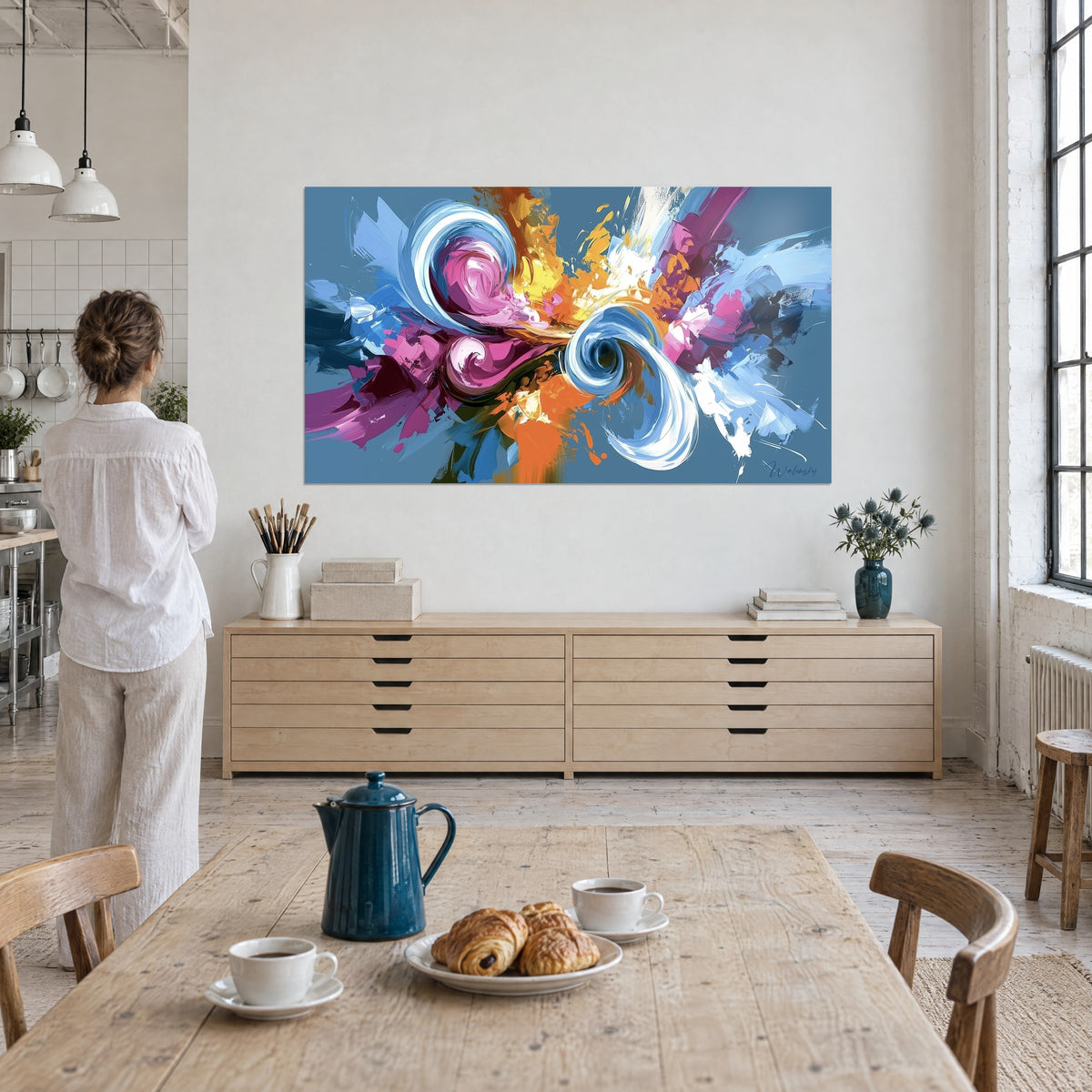 Tableau éclaboussures abstraites fuchsia, jaune et blanc crème, femme de dos près d'une table de petit-déjeuner dans un loft