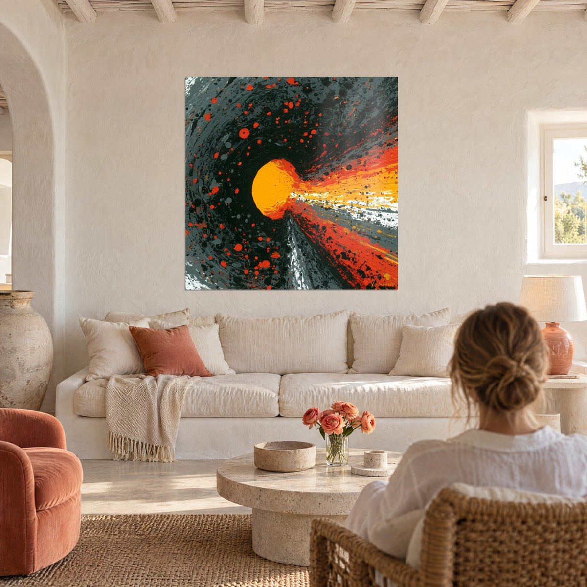 Wall art of a blazing orange sphere streaking through a swirl of charcoal and bright red, above a sofa in a bright living room