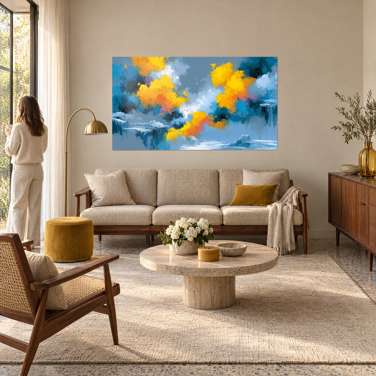 Wall art with saffron-yellow clouds on a petrol-blue background, frozen cliffs below, hanging above a sofa in a bright living room
