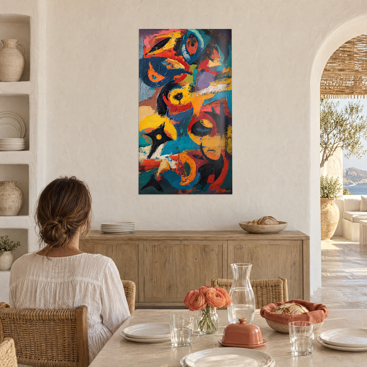 Cuadro fresco de planos ocre amarillo y azul noche con formas ovaladas perfiladas en negro, mujer sentada a una mesa de espaldas, comedor de paredes encaladas
